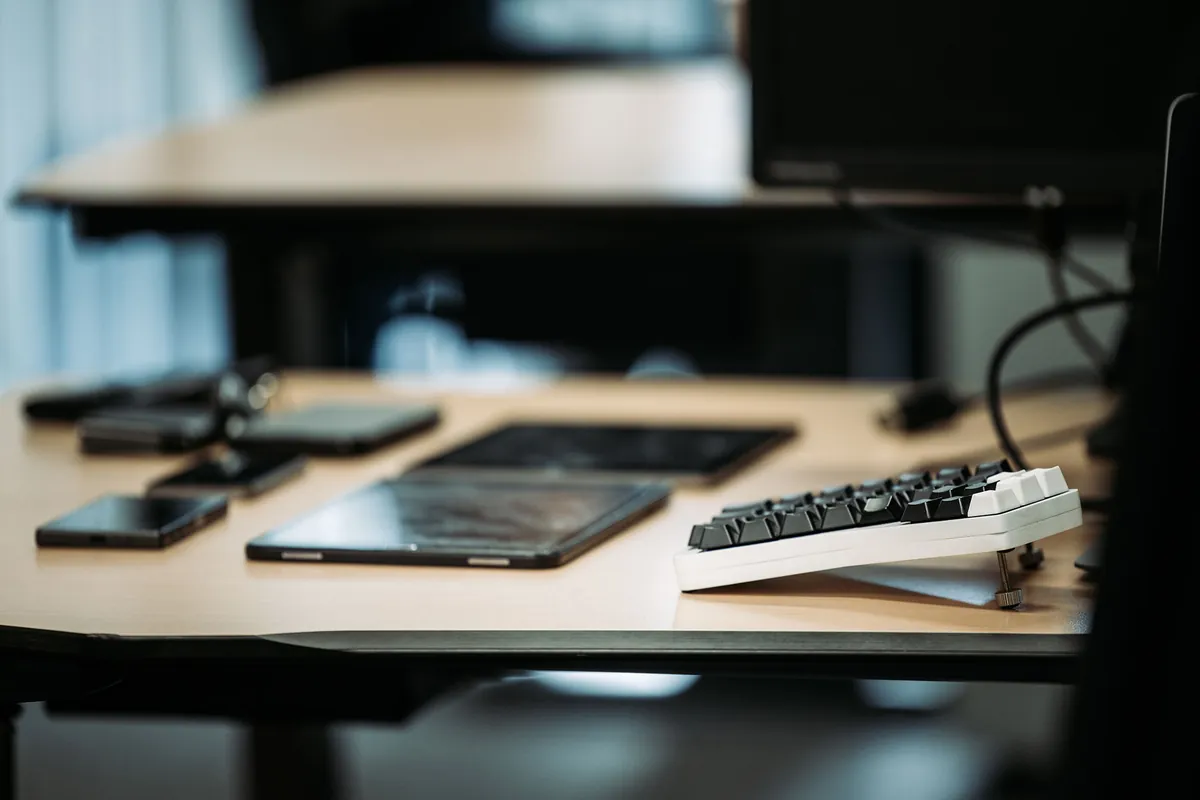 Een opgeruimde werkplek bij Infodatek Group met laptop, telefoon en toetsenbord.