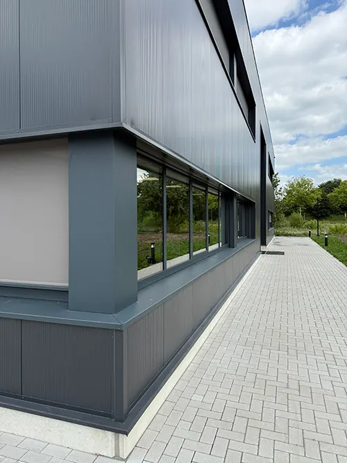 De gevel van het kantoor van Infodatek Group, met een pad langs het gebouw.