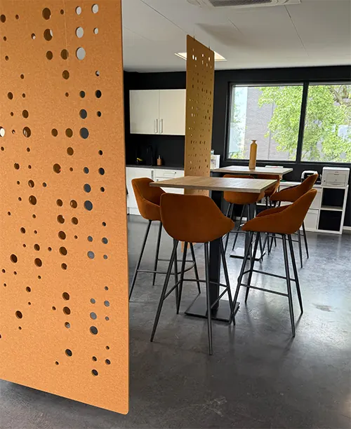 De kantine van Infodatek Group met hoge tafels en een oranje wand.