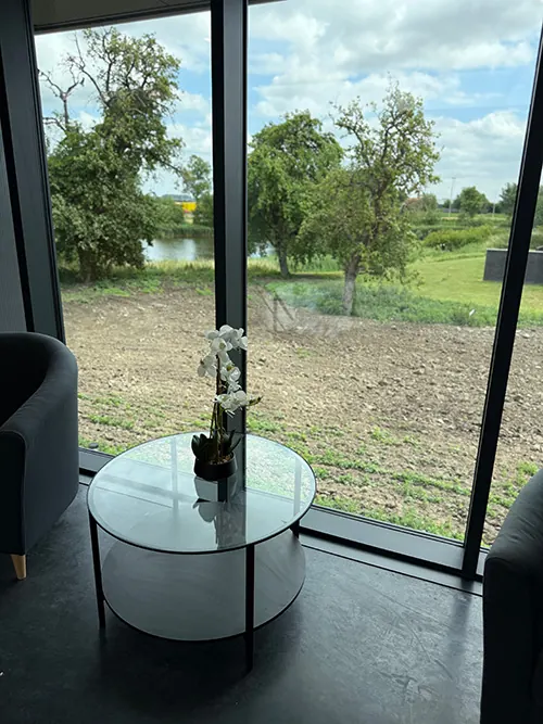 Uitzicht vanuit het kantoor van Infodatek Group op het groen, met een tafeltje bij het raam.