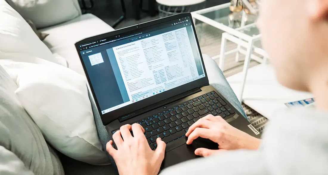 Iemand werkt op een laptop vanaf de bank.